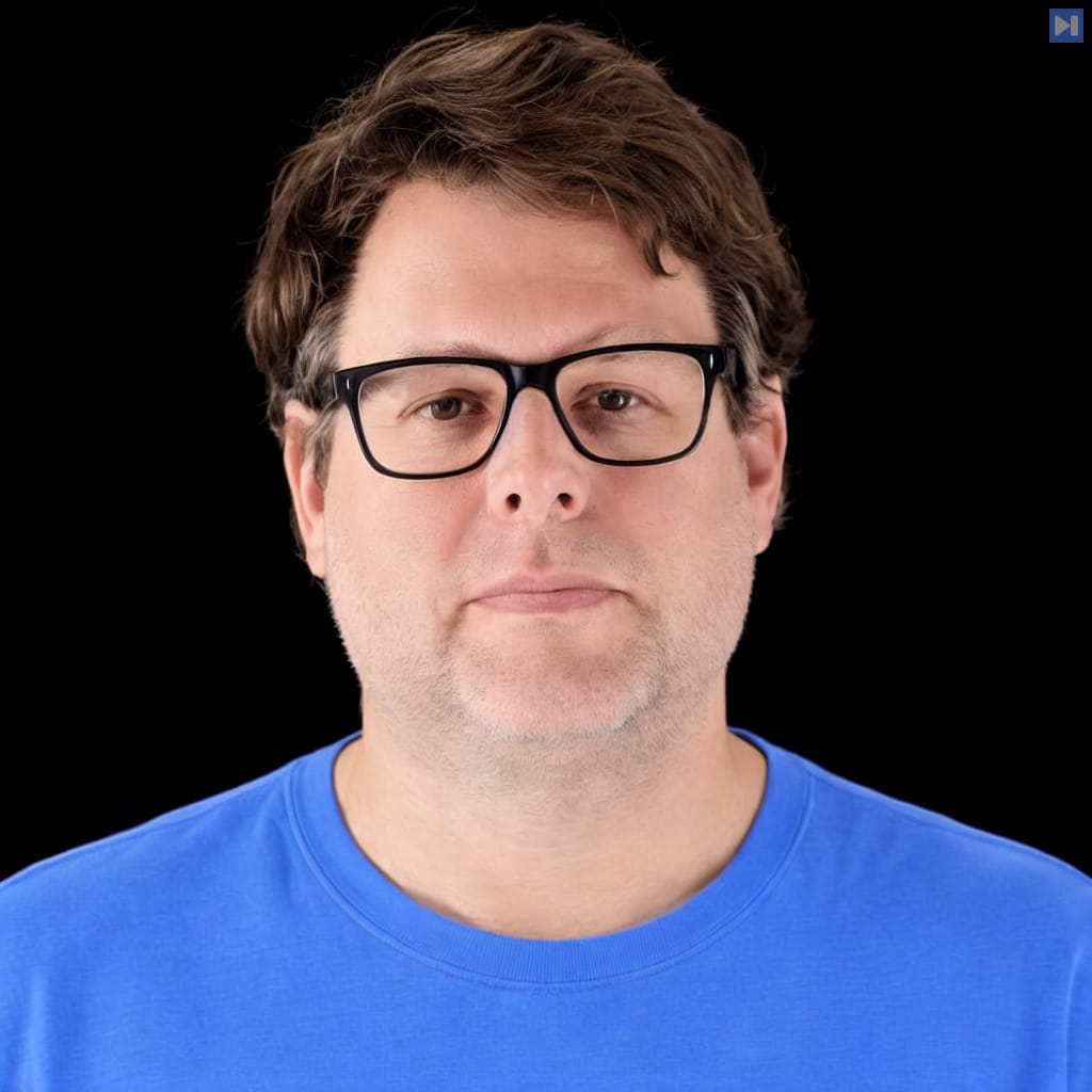 Head-and-shoulders portrait of Aaron Stanley against a black background.
