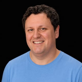 AI-generated portrait of Adam Becker wearing an AI Videos-blue top against a black background.