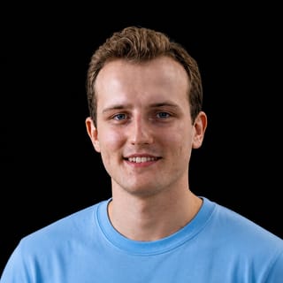 AI-generated portrait of Alexander Meinke wearing an AI Videos-blue top against a black background.