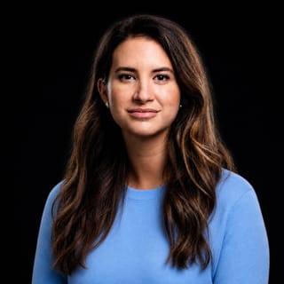 AI-generated portrait of Allie K. Miller wearing an AI Videos-blue top against a black background.