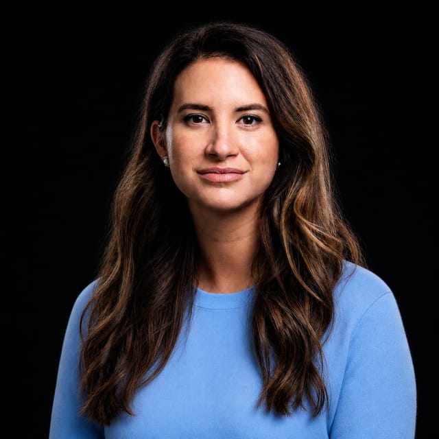 AI-generated portrait of Allie K. Miller wearing an AI Videos-blue top against a black background.