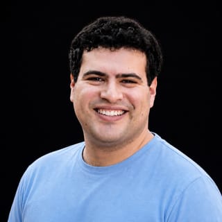 AI-generated portrait of Ari Morcos wearing an AI Videos-blue top against a black background.