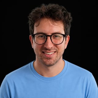 AI-generated portrait of Billy Howell wearing an AI Videos-blue top against a black background.