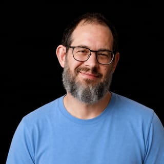 AI-generated portrait of Chris Best wearing an AI Videos-blue top against a black background.