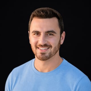 AI-generated portrait of Dan Zakon wearing an AI Videos-blue top against a black background.