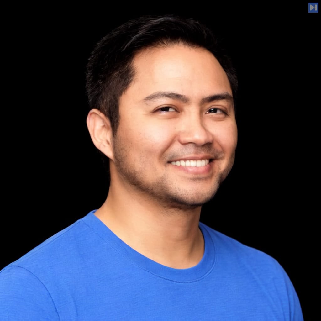 Head-and-shoulders portrait of Dean Quiñanola against a black background.