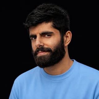AI-generated portrait of Dwarkesh Patel wearing an AI Videos-blue top against a black background.