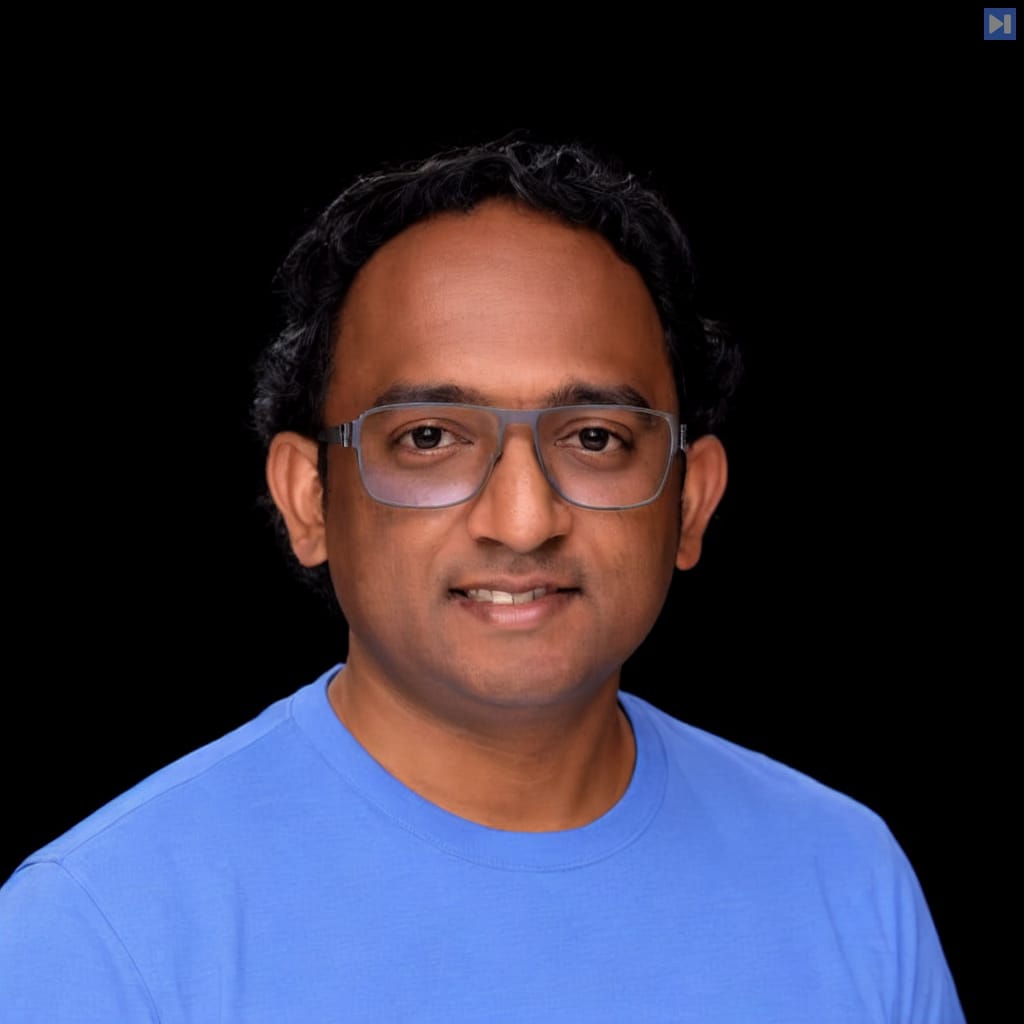 Head-and-shoulders portrait of Gautam Korlam against a black background.