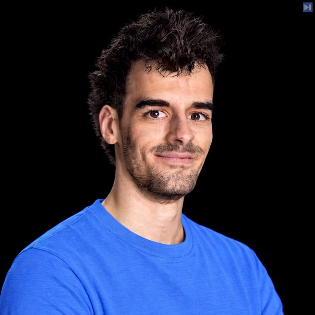 Ignacio Martinez in a plain light attention-blue crewneck, with natural hair highlights and neutral subject lighting against a pure black background.