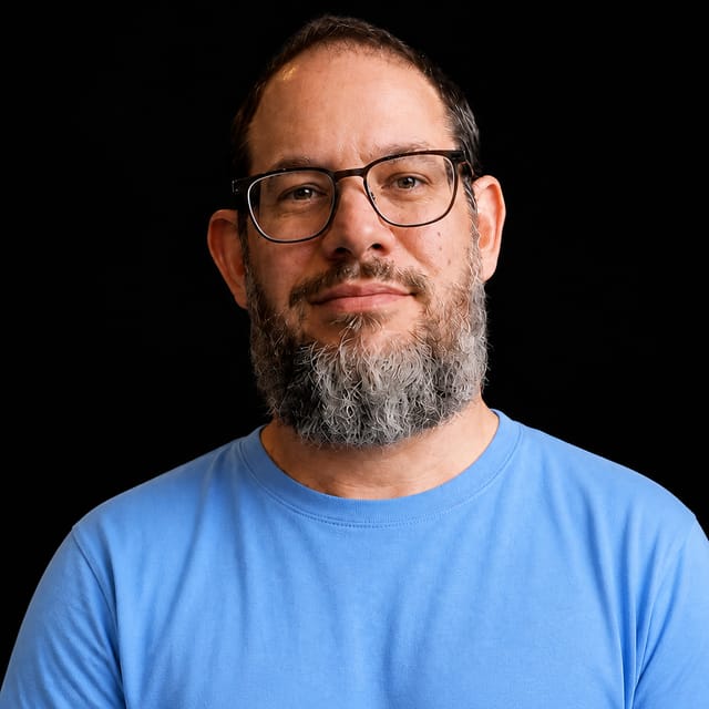 AI-generated portrait of Nate B Jones wearing an AI Videos-blue top against a black background.