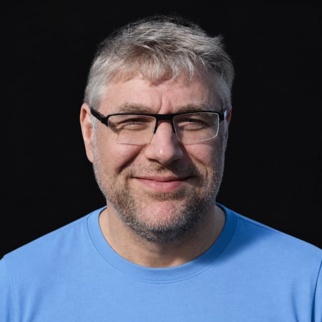 AI-generated portrait of Patrick Debois wearing an AI Videos-blue top against a black background.