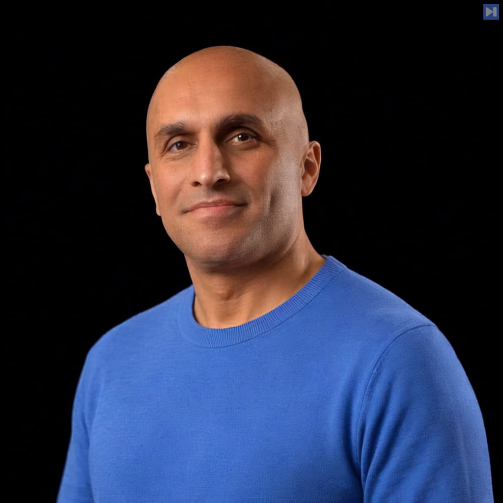 Head-and-shoulders portrait of Qasar Younis against a black background.