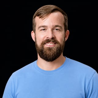 AI-generated portrait of Rob Toews wearing an AI Videos-blue top against a black background.