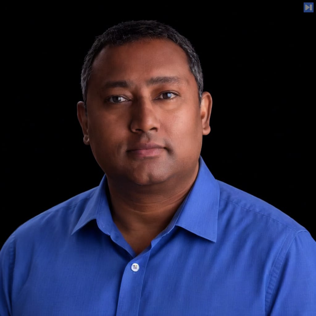 Head-and-shoulders portrait of Royden D'Souza against a black background.