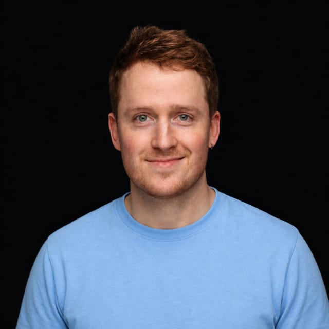 AI-generated portrait of Sebastian Fox wearing an AI Videos-blue top against a black background.