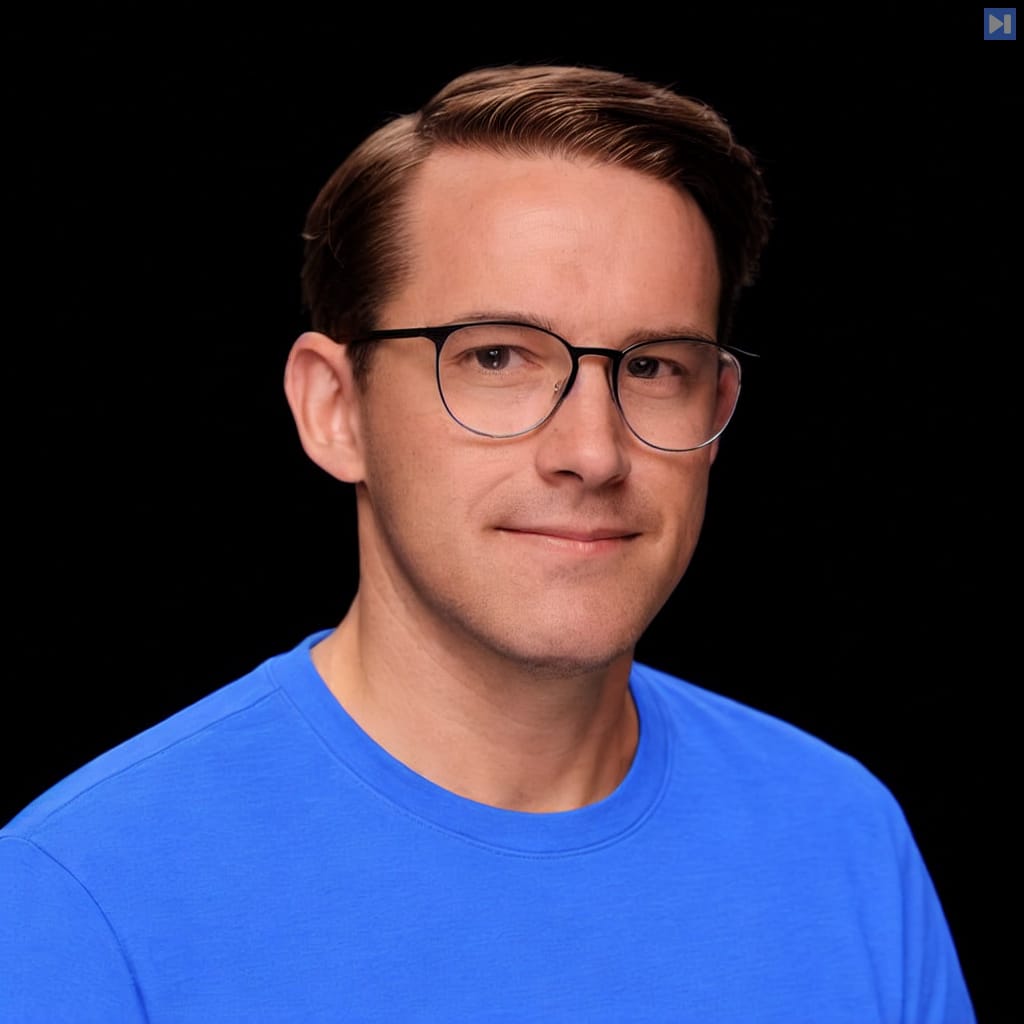 Head-and-shoulders portrait of Stephen Kent wearing a blue T-shirt against a black background.
