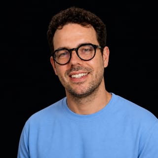 AI-generated portrait of Thorsten Ball wearing an AI Videos-blue top against a black background.