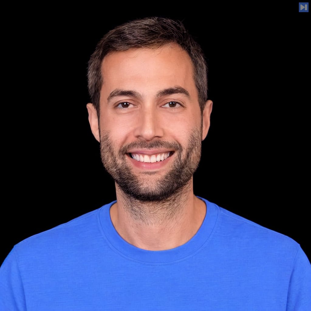 Head-and-shoulders portrait of Udi Menkes against a black background.