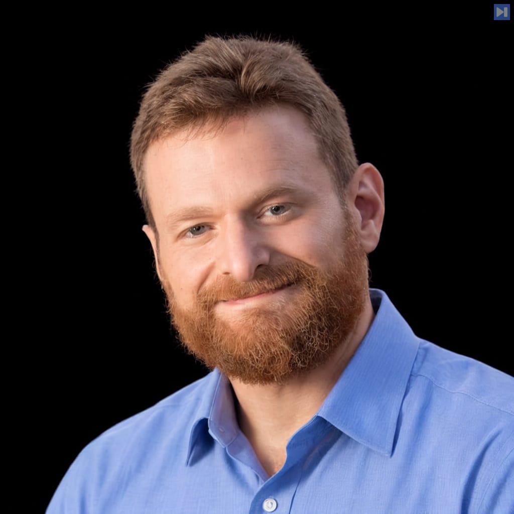 Head-and-shoulders portrait of Zach Blumenfeld against a black background.